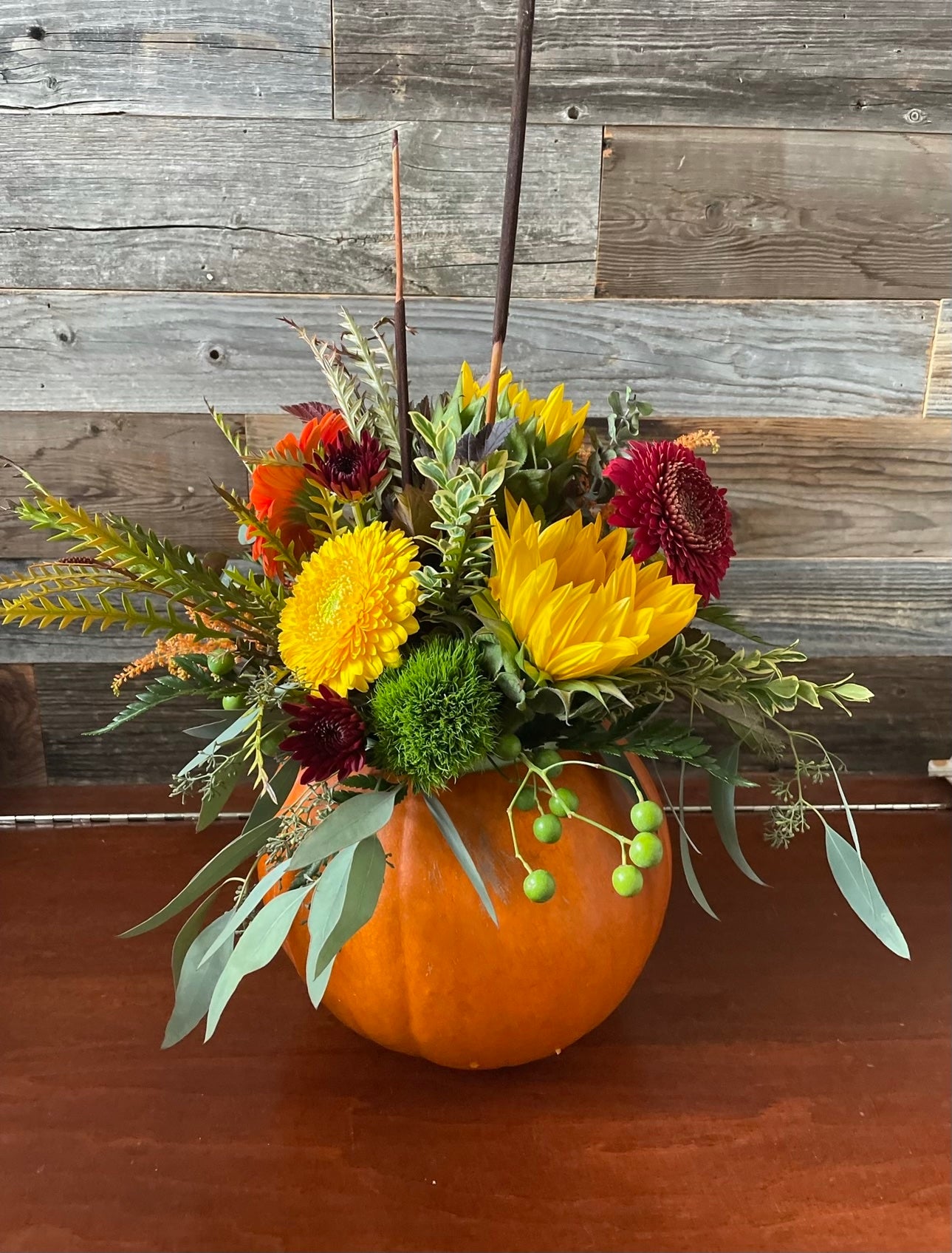 Colourful fall floral pumpkin arrangement