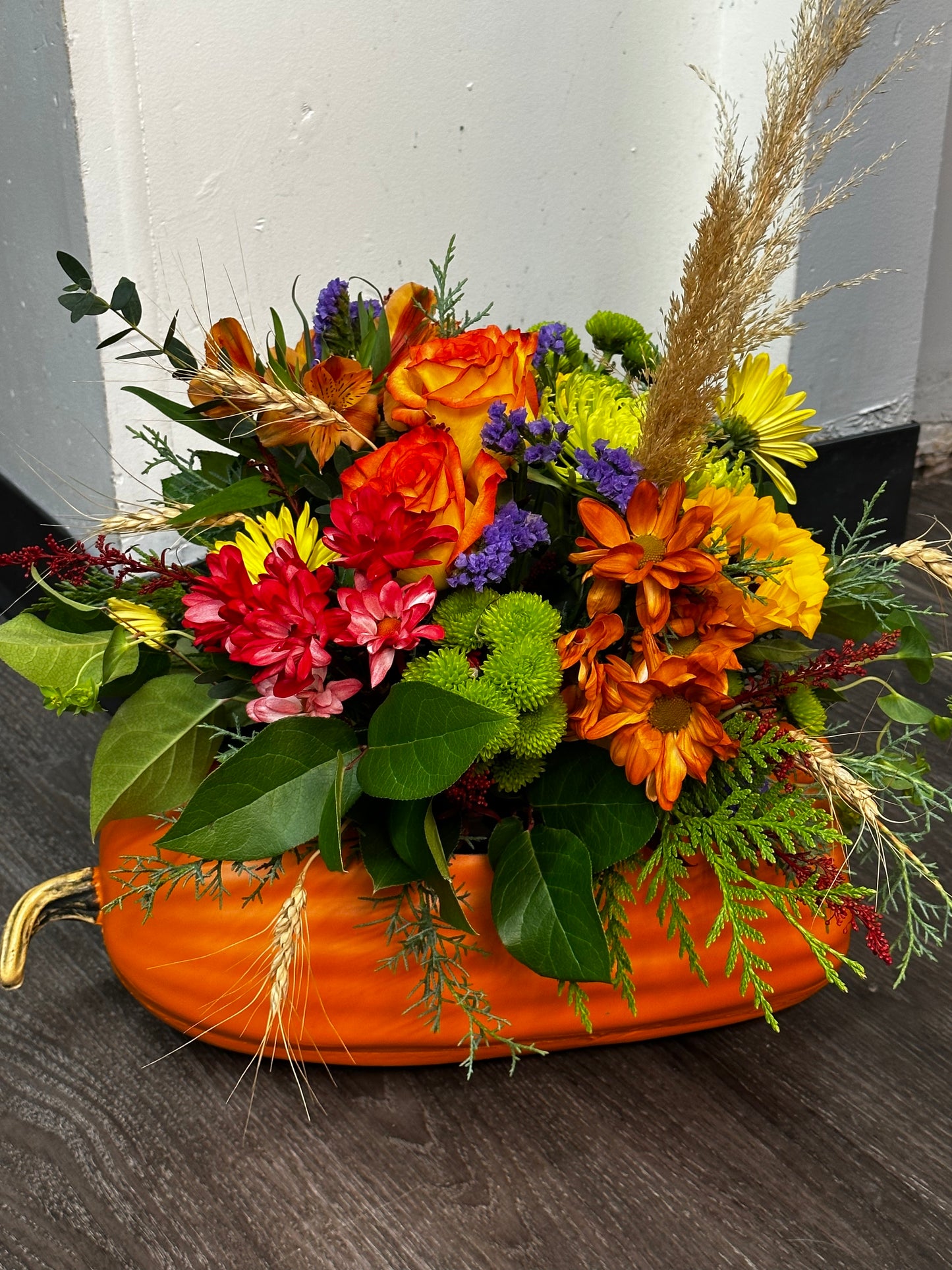 Colourful fall floral pumpkin arrangement